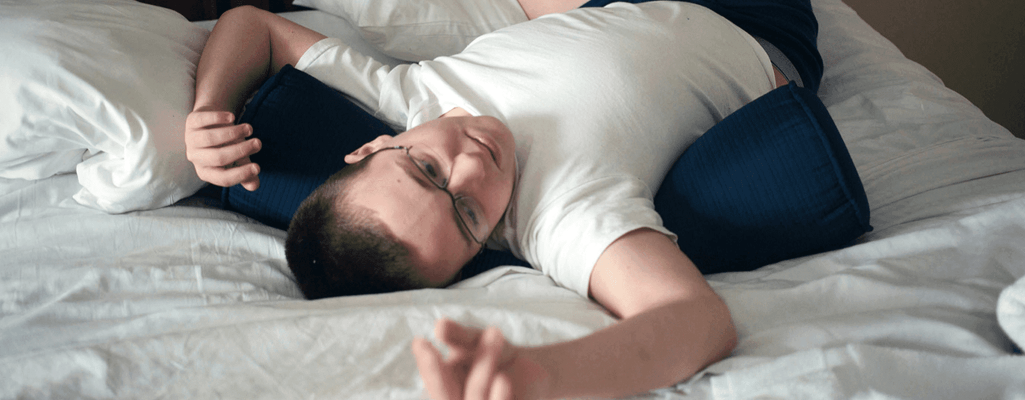 A 19-year-old man who is on the autistic spectrum lies on a bed playing with a piece of string